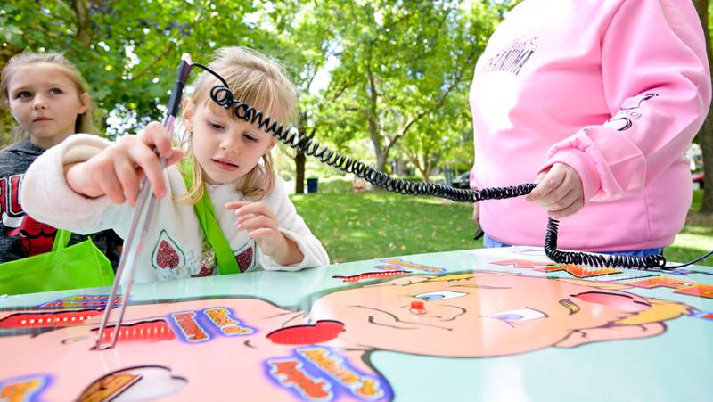 Emilie Gavaris, 4 plays a large “operation” game during the annual Scarecrow Festival on Saturday, Oct 11, 2025 in St. Charles.