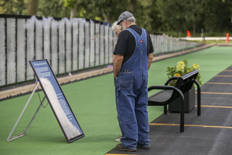 A couple reads a sign in front of the Vietnam Traveling Memorial Wall Thursday, Aug 21, 2025  in Romeoville.