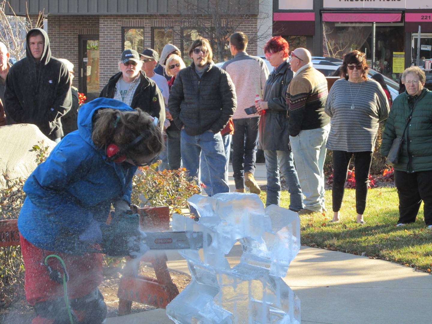 Spectators watch a live ice sculpting by Nadeau's Ice Sculptures, Saturday, Nov. 26, 2022, at Heritage Park in Streator as part of the Keeping Christmas Close to Home celebration.