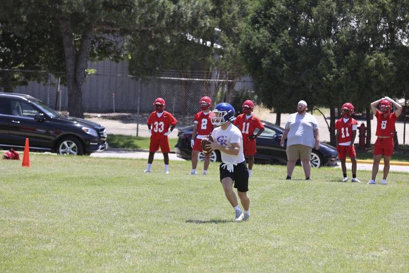 Genoa-Kingston senior quarterback Nolan Perry rolls out for a pass on Sunday at a 7-on-7 tournament at NIU.