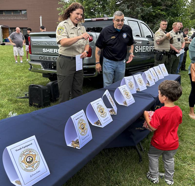 Ogle County Sheriiff Department Chief Deputy Danielle Hardesty and Chaplain Gary Cortese talk with Emmett Smith, 2, of Byron, during National Night Out in Byron on Tuesday, Aug. 6, 2024. The event was held in conjunction with the Byron fire and police departments.