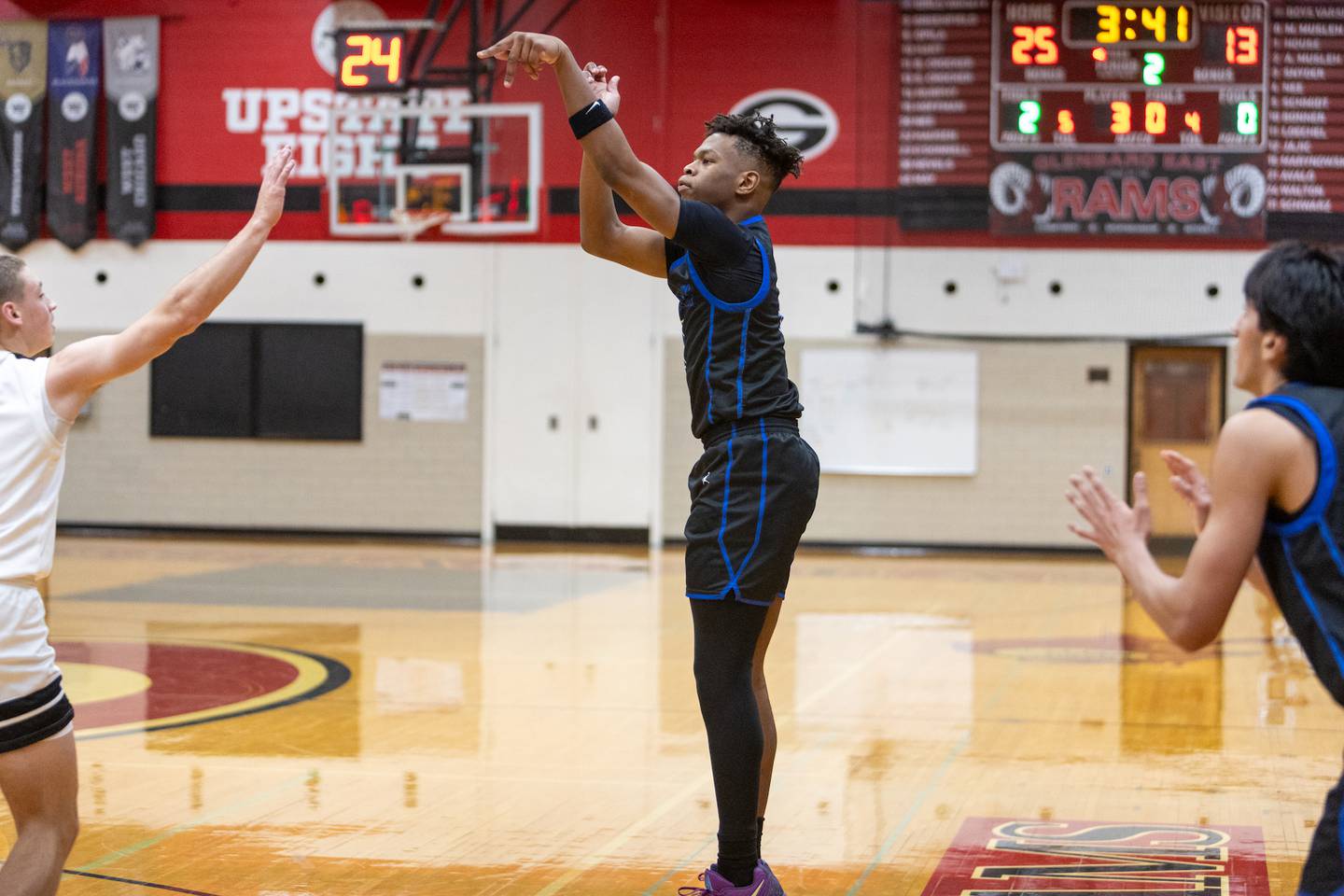 St. Charles North's EJ Mondesir shoots a three pointer against Glenbard East Tuesday Dec.2,2025 in Lombard.