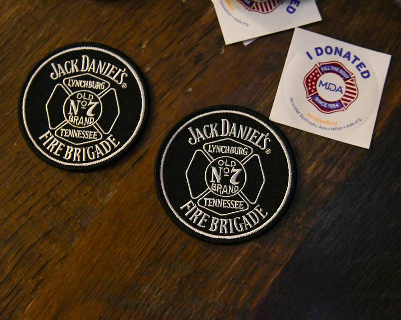 Patches and stickers sit on tables at Fatty’s Pub and Grille in DeKalb on Wednesday, Nov. 27, 2024, during the DeKalb Fire Fighters Local 1236 union's annual Tip A Firefighter event to fundraise for the Muscular Dystrophy Association.