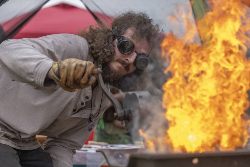 Blacksmith Ian Ellis stokes the flame of his forge demonstrating his craft for onlookers at the Cedar Creek Renaissance Faire on Saturday, Sept. 28, 2024, at Cedar Creek Ranch.