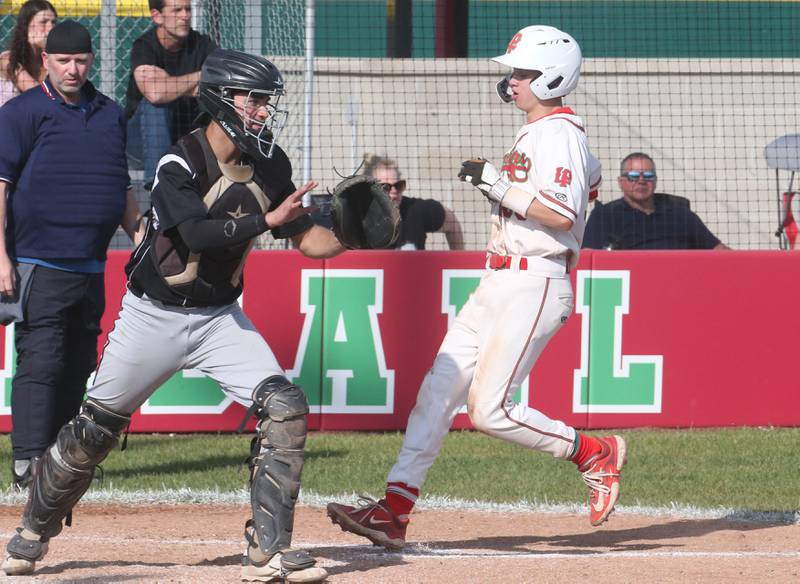 L-P's Jett Hill scores the teams first run while Kaneland catcher Nate Campbell waits for the late throw on Tuesday, May 13, 2025 at Huby Sarver Field at the L-P Athletic Complex in La Salle.