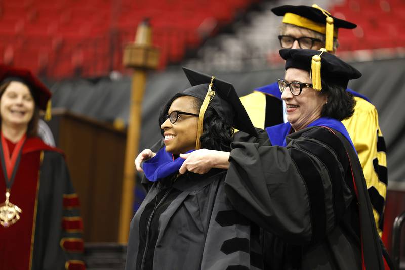 A Northern Illinois University graduate student receives her accolades during a May 12, 2023 Commencement ceremony at the NIU Convocation Center in DeKalb.