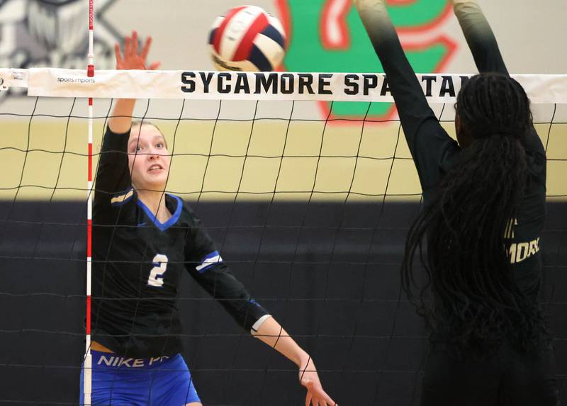Burlington Central's Haidyn Schatz tries to spike the ball by Sycamore's Khiara  Thomas Tuesday, Oct. 29, 2024, during their Class 3A regional match at Sycamore High School.
