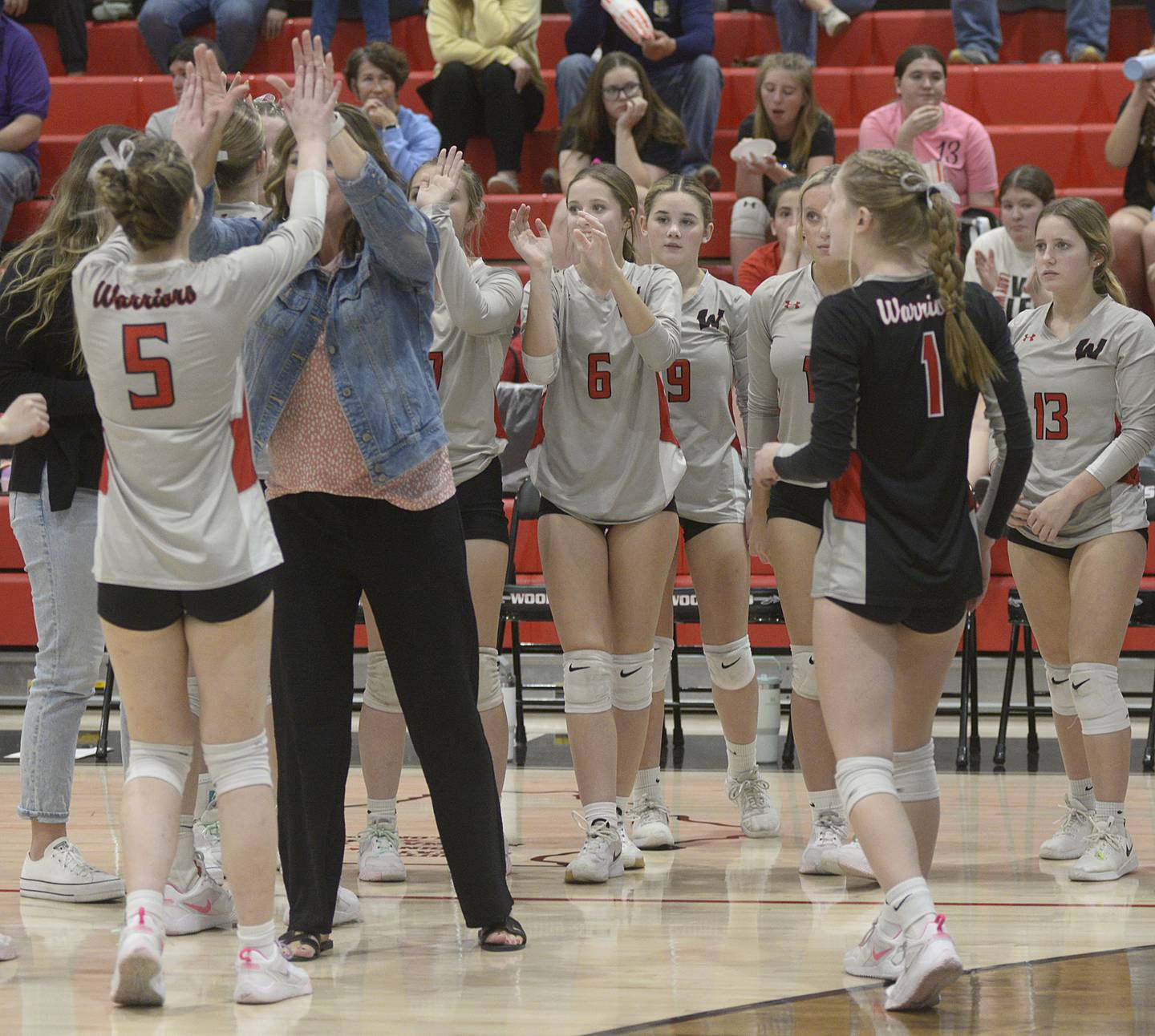 The Woodland players and coaches celebrate their first-set win over Marquette on Thursday at Woodland.
