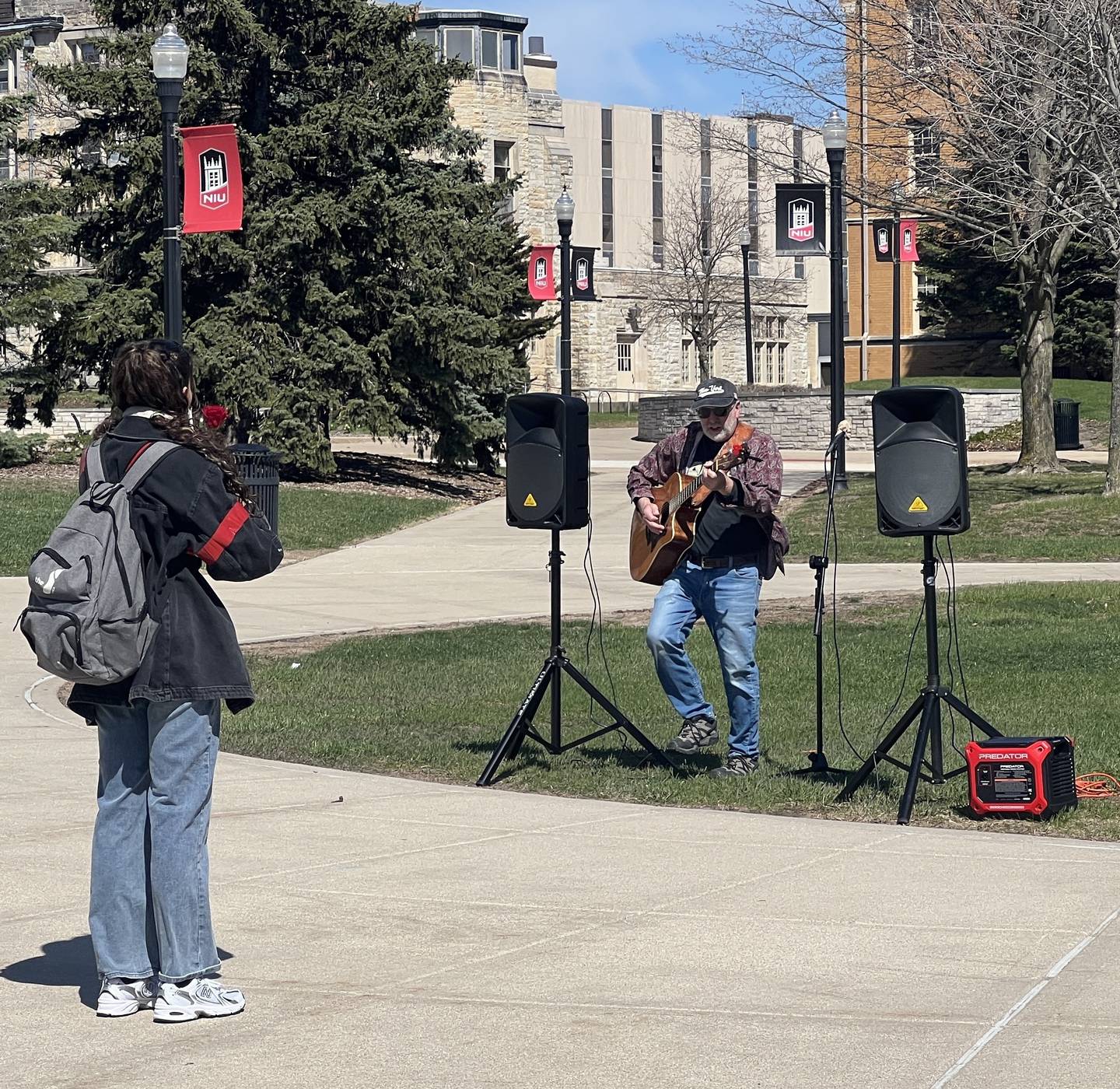 Northern Illinois University junior Vivika Ramos, 20, listens to Mike Warfel perform on NIU's campus on April 8, 2026.