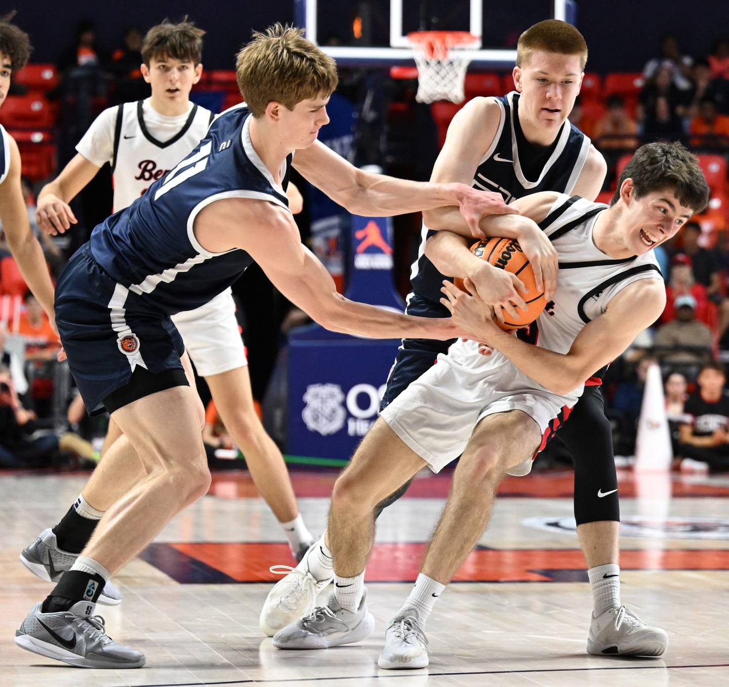 Benet Academy's Michael Doyle gets fouled by Evanston's Ben Ojala, upper right, as Theo Rocca of the Wildkits teis to grab the ball during the IHSA Class 4A boys basketball state semifinals at State Farm Center on Friday, March 14, 2025 in Champaign.