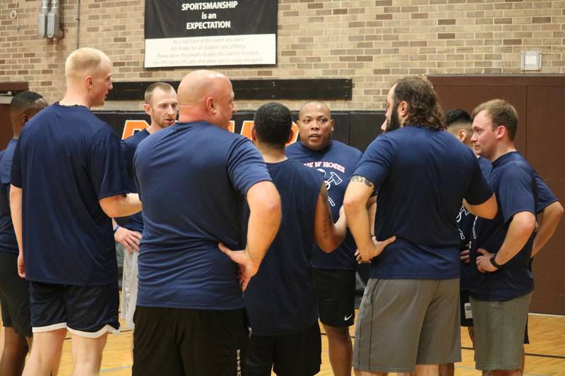 The Guns and Hoses huddle up to strategize Monday, Dec. 5, 2022 in the Toys for Tots community basketball game.