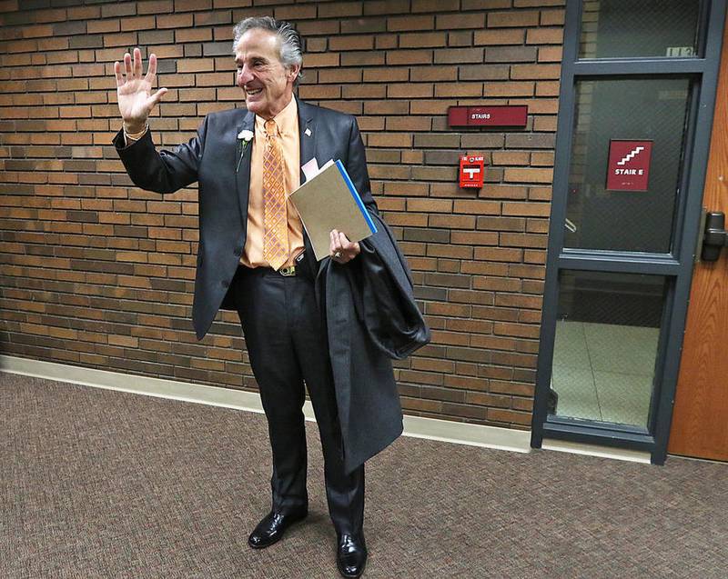 Former McHenry County State's Attorney Lou Bianchi waves to a former coworker as he leaves the courthouse after attending Patrick Kenneally's oath of office ceremony on December 1, 2016.