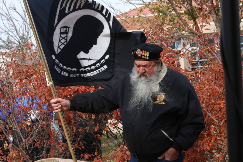 Navy Veteran Dan Savitch holds the POW flag to commemorate the fallen 24 soldiers who attended Hall High School that died in WWII during the Veterans Day program on Tuesday, Nov. 11, 2025 in the Hall High School