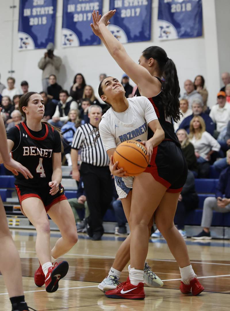 Benet's Emma Briggs (24) stops Nazareth's Allia Von Schlegell (1) drive to the basket during a girls varsity basketball game between Benet and Nazareth academies on Saturday, Dec. 14, 2024 in La Grange Park.