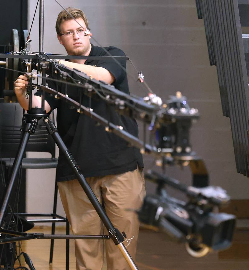Steven Jamrog, a Spartan TV assistant who is a Sycamore High School graduate, operates the crane during a girls basketball game Friday, Feb. 17, 2023, in the gym at the school.