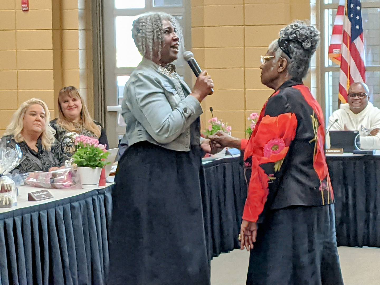 Outgoing Oswego School Board President LaTonya Simelton, left, honors her fourth-grade teacher, Willie Etta Bonner Wright, at the May 5 School Board meeting.