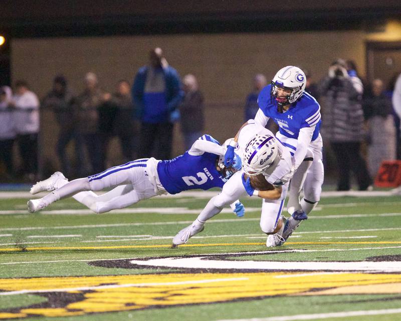 Burlington Central's Caden West is tackled by Geneva's Dane Turner (2) and Dylan Reyes (5) at the Class 6A second-round playoff game on Saturday Nov.9,2024 in Geneva.