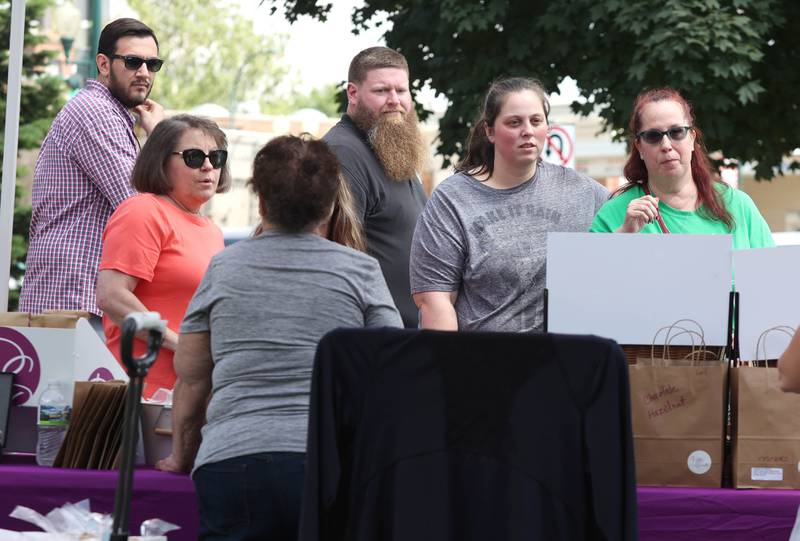 Visitors check out the items at the Petite Sweets by Cristy booth Tuesday, June 7, 2022, at the Sycamore Farmers Market on the lawn of the DeKalb County Courthouse.