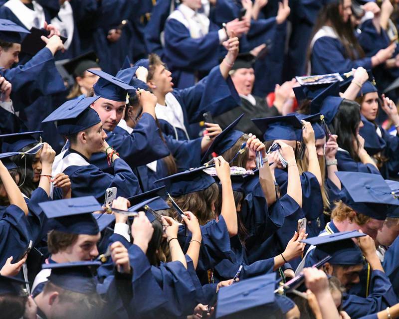 Oswego East graduates move their tassels to the other side of their caps signifying they are officially alumni during the commencement ceremony on Saturday May 17, 2025, held at the Convocation Center in DeKalb.