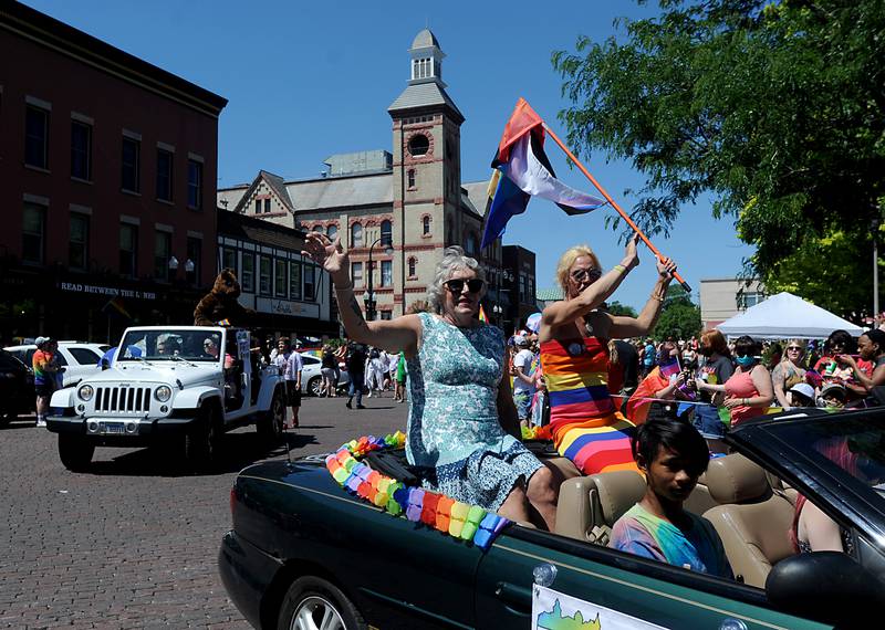 Grand Marshal Danielle Aylward and Kristal Larson wave as they ride in the parade Sunday afternoon, June 13, 2021, during the Woodstock Pridefest and Parade around the Historic Woodstock Square.