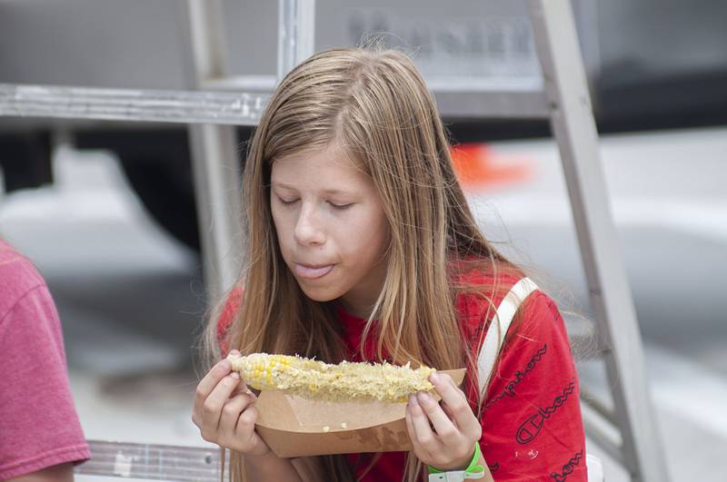 Kolbie Theodore, 11, of Morrison tastes some sweet roasted corn Saturday, July 30, 2022 at Morrison’s first ever Shuckfest. The first time festival featured music, food, vendors and fun and games for the kids.