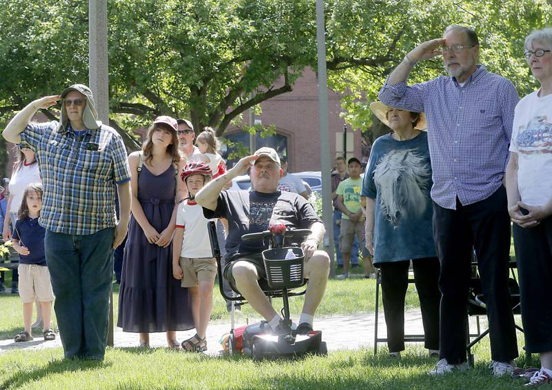 People salute as the American Flag is raised during the Woodstock VFW Post 5040 City Square Memorial Day Ceremony and Parade on Monday, May 29, 2023, in Woodstock.