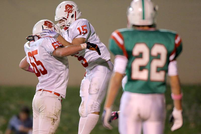 Ottawa's Alex Hartman (15) celebrates with Tyler Skoloek (65) after the Pirates' game-opening touchdown run in 2012 with as La Salle-Peru's Logan Zeman (22) looks on.