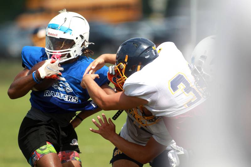 Glenbard South’s Elijah Donahue carries the ball during a joint practice with Sterling and Oswego East football teams on Tuesday, July 15, 2025 in Oswego.