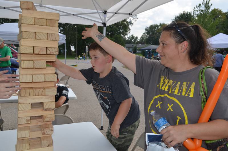 Waylon Denning, of Lyndon, keeps a watchful eye on the blocks as he plays Jenga with the assistance of his mother, Shellie Morse, at Resthave Care and Rehabilitation's Family Fun Day on Sunday in Morrison.