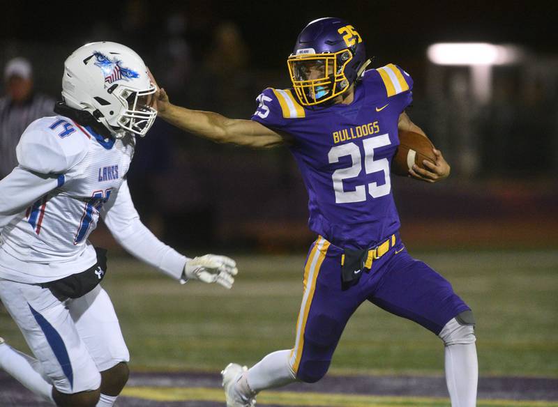 Wauconda's Connor Vanselow (25) stiff arms Lakes' Prodive Matumona-Nzama to gain extra yards during Friday’s football game in Wauconda. Vanselow scored multiple touchdowns in game.