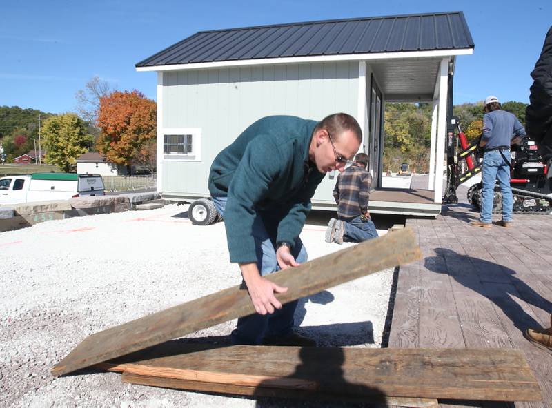 Utica mayor Dave Stewart helps gather cribbing to erect one of twelve huts into the retail site plaza on Wednesday, Oct. 16, 2024 downtown Utica.