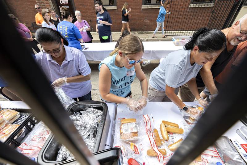 Lydia Escamilla (left), Jayci Bormann and Rhoda Devers dish up the dogs Friday, Aug. 1, 2025, during Sterling’s Hot Dog Day. A dog would cost you one quarter for the annual al fresco luncheon.