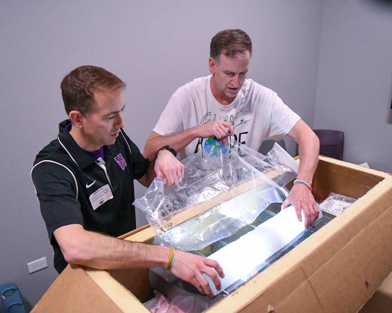 Mike Heinz, right, and Jeff Grant gets approximately 1,270 year old ice for display from Greenland at Downers Grove North High School during The Climate of Hope Conference 2024, held on Friday March 1, 2024.