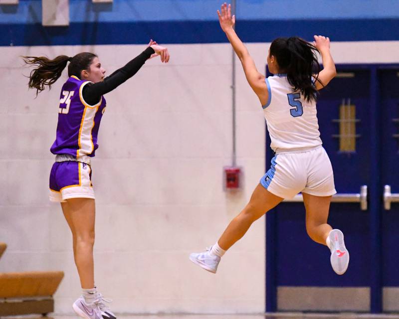 Downers Grove North's Caitlin Sandrige (25) makes a three-point shot while Downers Grove South's Kayla Meyer (5) tries to block the shot during the game on Saturday Dec. 21, 2024, held at Downers Grove South High School.