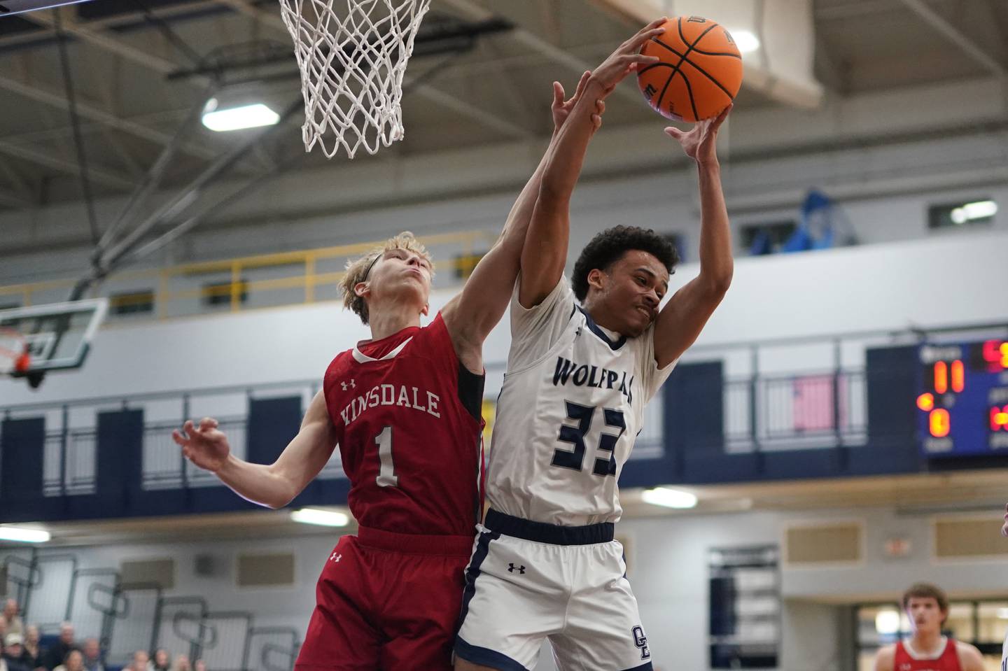 Oswego East's Michael Rembert (33) rebounds the ball against Hinsdale Central's Eric Kozys (1) during a hoops for healing tournament basketball game at Oswego East High School on Tuesday, Nov. 26, 2024.