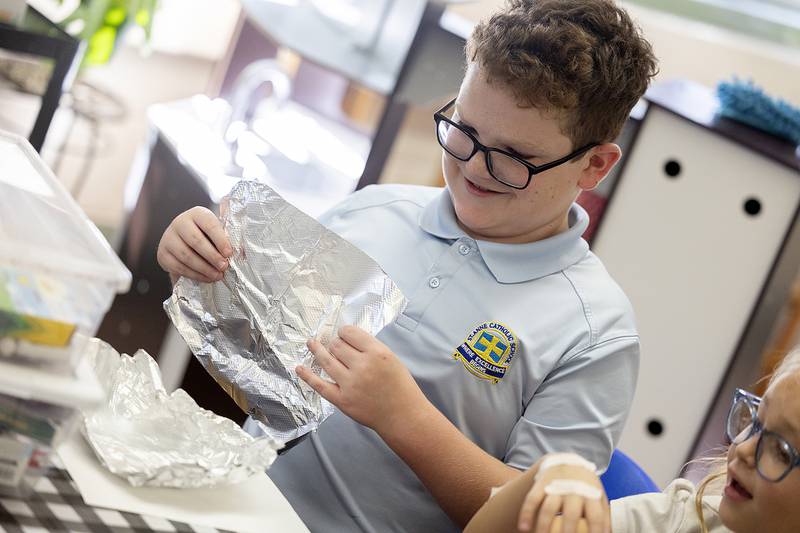 St. Anne’s fifth grader Nolan Etheridge works on forming a vessel that will be used to measure a volume of popcorn Thursday, October 10, 2024, during a STREAM event at the school.