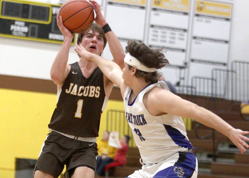 Jacobs’  Ben Jurzak, left, shoots as Lake Zurich’s Jonathan Fleaka defends in Hinkle Holiday Classic boys basketball tournament game action at Jacobs High School Tuesday.