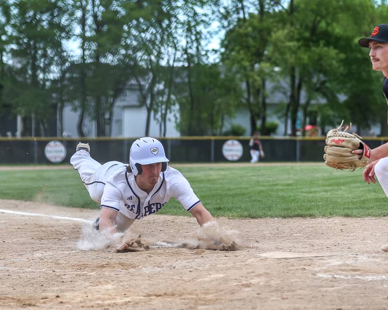 Plano's Kaden Aguirre (99) dives into home for a run during baseball game between Sandwich at Plano.  May 8, 2024