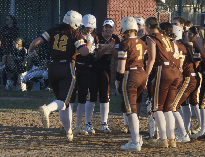 Jacobs' Skylee Ferrante is greeted by her teammates after hitting a home run during a nonconference softball game against Marengo on Monday, March 9, 2026, at Marengo High School.
