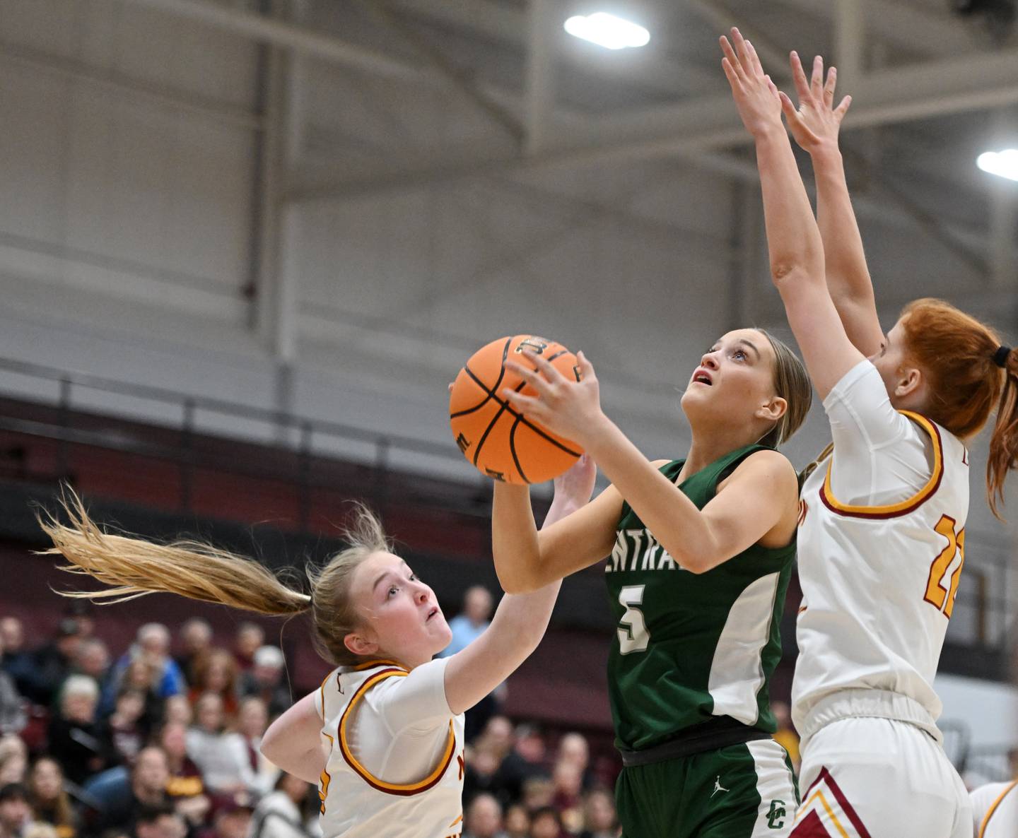 Grayslake Central's Katelyn Marcelain goes to the baseket between Montini's Sophie Maquet, left, and Audrey Kinney during the Hersey Class 3A supersectional on Monday, March 3, 2025 in Arlington Heights.