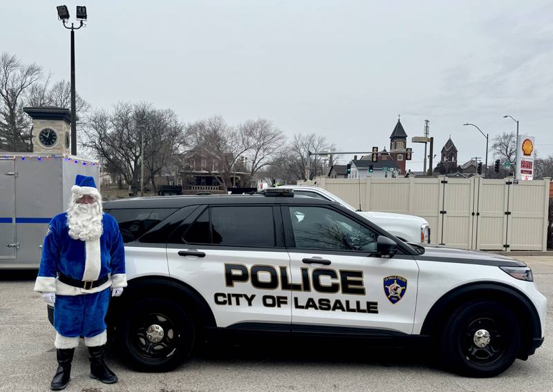 Officer Santa stands in front of a city of La Salle police cruiser on Saturday, December 14, 2024; ahead of delivering presents to more than 100 local children.