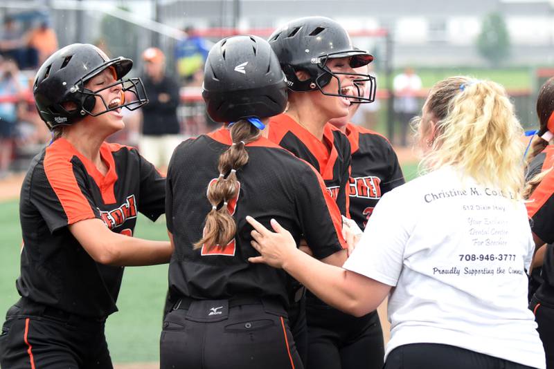Beecher's Ava Lorenzatti, center, is mobbed by teammates and coaches after her game-tying two-run home run in the sixth inning of the Class 2A State championship game against Carterville Saturday, June 7, 2025 at the Louisville Slugger Complex in Peoria.