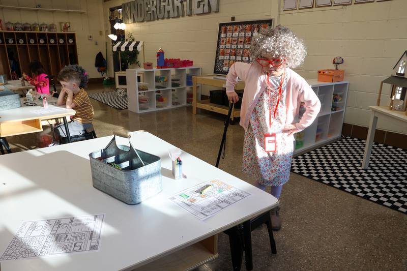 Shabbona Elementary School kindergartener Posie Diaz embraces her 100-year-old character, walking back to her table using a cane and holding her hip, during the 100th day of school on Monday, Feb. 9, 2026.