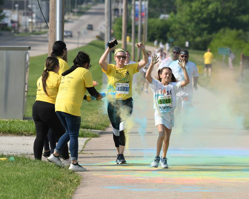 Charlee Gautcher( right) and Tina Gautcher, both of Sycamore, get sprayed with color powder as they run through a color station on Saturday, June 7, 2025, during the CASA DeKalb County 5k Color Run held at the Sycamore Middle School.