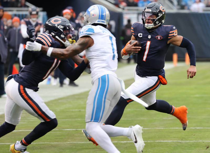Chicago Bears quarterback Justin Fields scrambles and gets a block from wide receiver Darnell Mooney on Detroit Lions cornerback Cameron Sutton during their game Sunday, Dec. 10, 2023 at Soldier Field in Chicago.