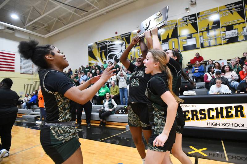 Bishop McNamara's Lydia Nugent, Leigha Brown and Trinity Davis are met by Eliana Isom, left, as they bring the IHSA Class 2A Herscher Sectional championship plaque to the team following the Fightin' Irish's 69-38 victory over Watseka-Milford on Thursday, Feb. 27.