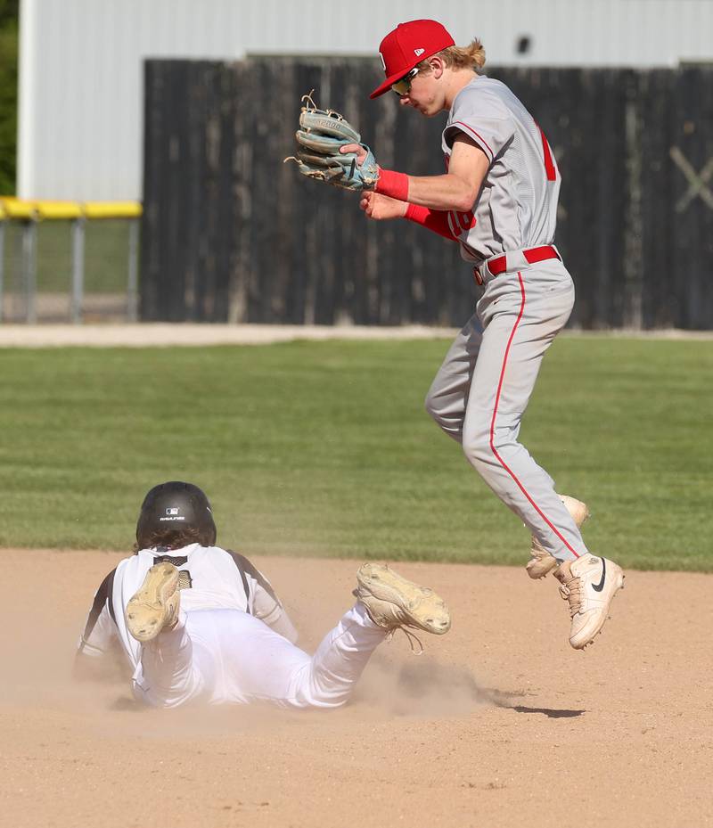 Sycamore's Tyler Lojko slides in with a stolen base as Ottawa’s George Shumway has to jump to catch the throw during their game Tuesday, May 6, 2025, at the Sycamore Community Sports Complex.