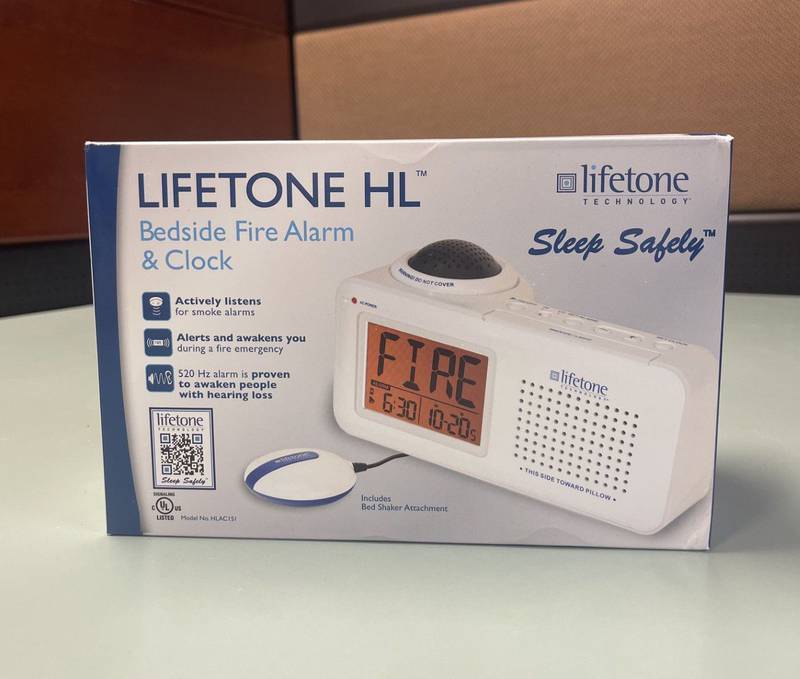 The Lifetone fire alarm in its box displaying the alarm and the bed shaker.