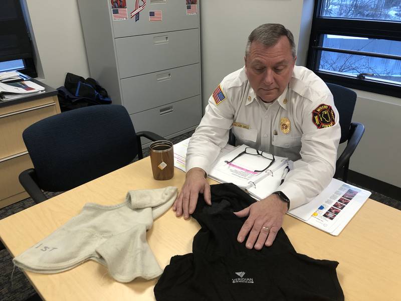 McHenry Township Fire Protection District Chief Rudy Rudy Horist shows the old hoods his firefighters wore under their helmets, right, and the new ones, left, that block up to 99% of particulates from reaching the skin, on Jan. 23, 2023.
