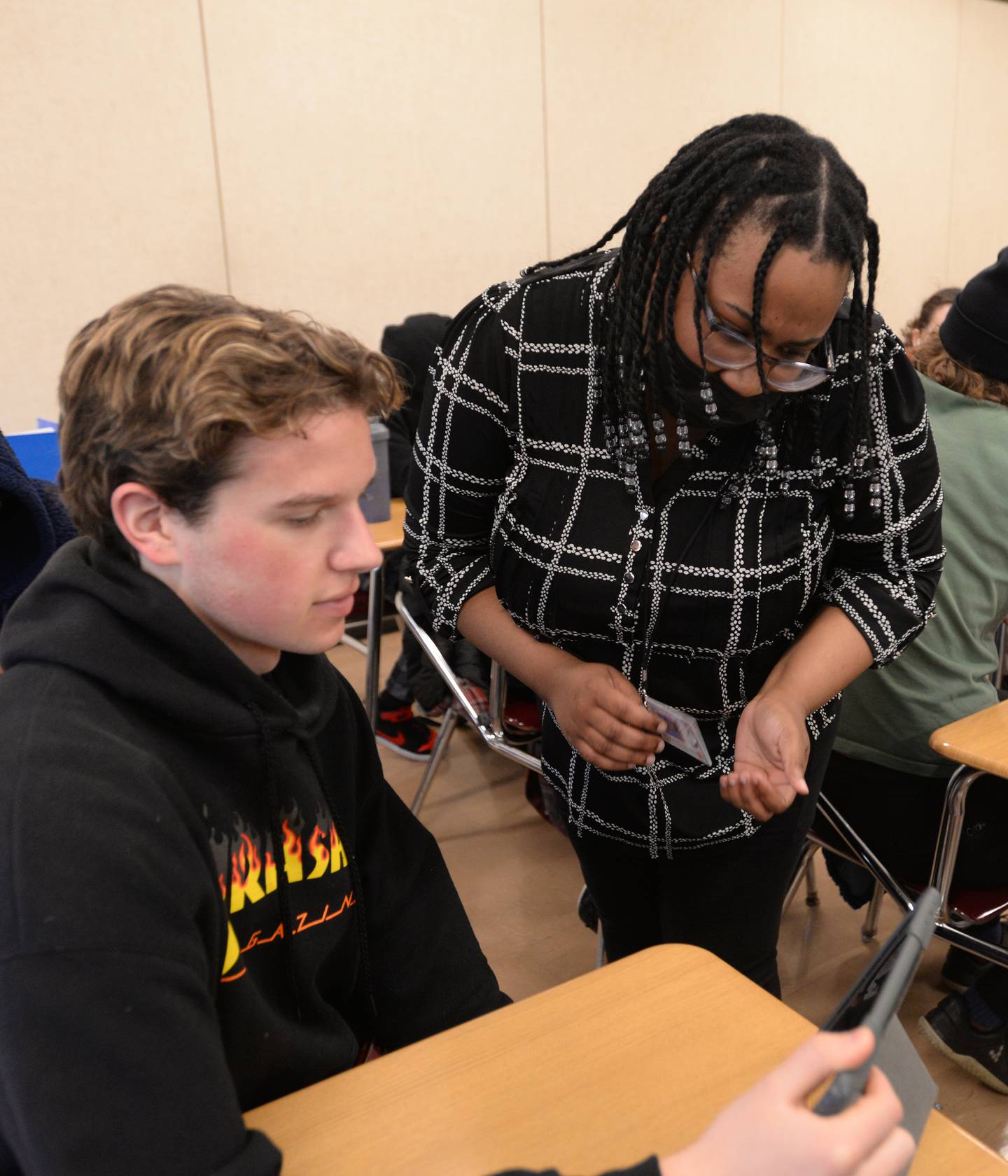 Glenbard East Social Studies teacher, Gariecia Rose assists students including Phoenix Smith while they participate in a live quiz Thursday March 16, 2023.